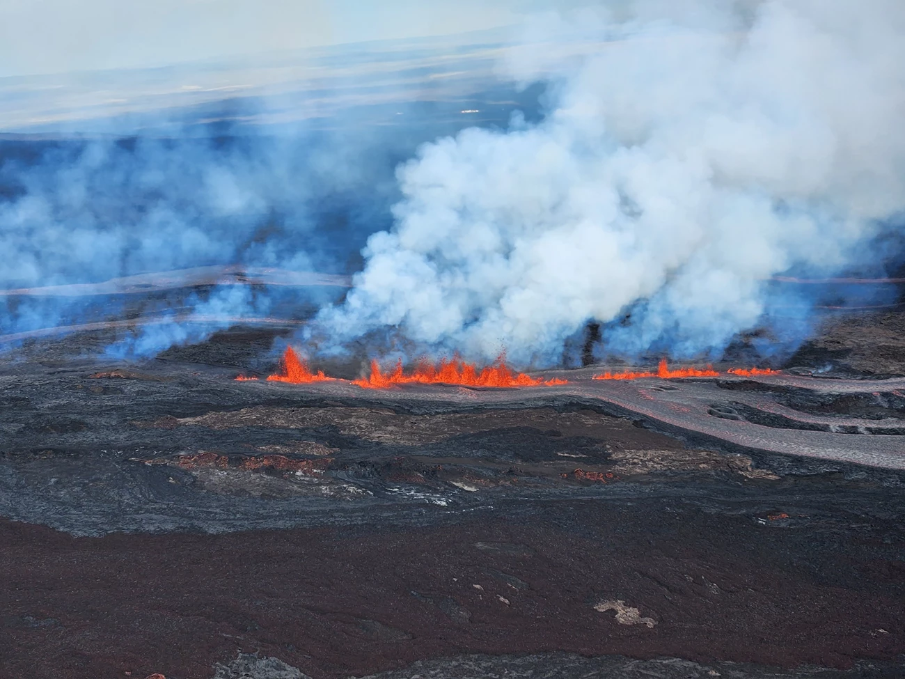 2022 eruption of Mauna Loa volcano in Hawaiʻi Volcanoes National Park aerial view of volcano erupting with red lava and clouds of ash