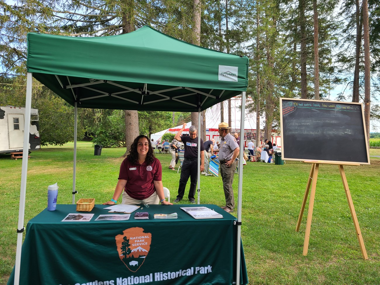 Cristina in her ACE uniform in front of a park service booth ready to talk to visitors outside