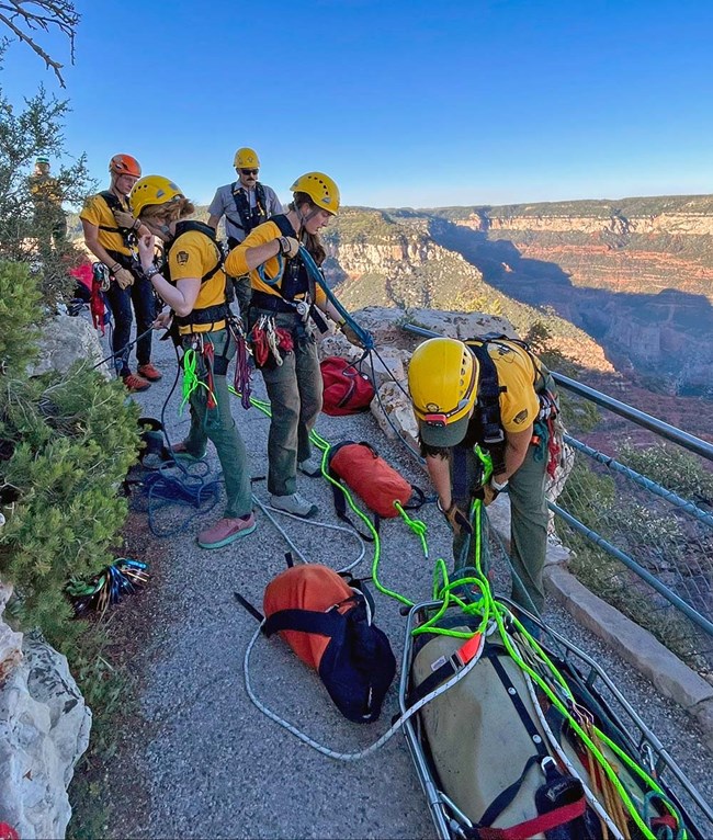 During the later afternoon, search and rescue personnel are preparing ropes and equipment in order to perform a technical rope rescue.