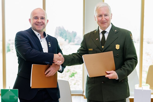 2023 CRLA-Triglav SP renewal The park superintendents shake hands after signing the sister park renewal document.