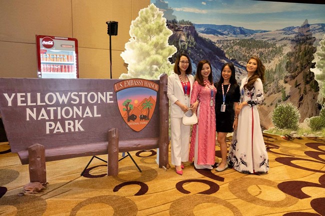 2023 Embassy-Hanoi Four women from Vietnam stand in front of a backdrop of Yellowstone National Park.
