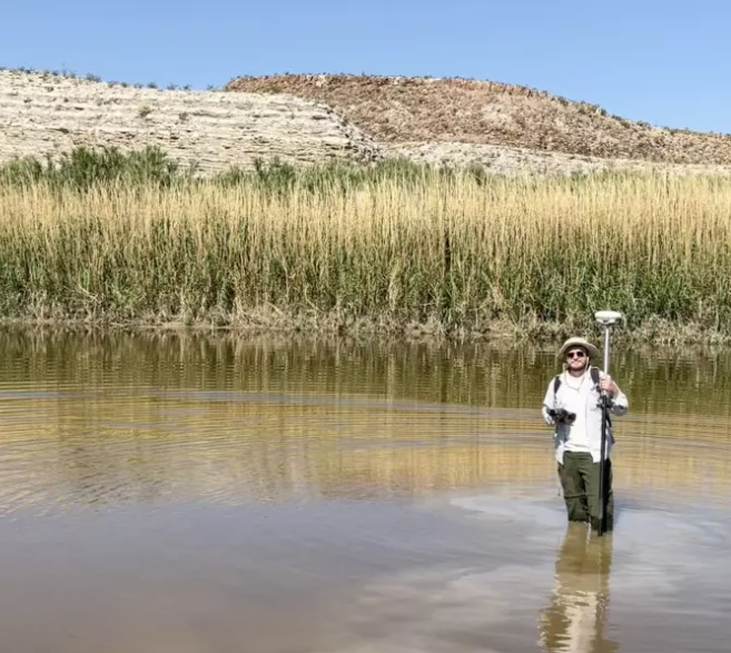 2023 IVIP Josh Reynolds International Volunteer Josh Richards stands in a stream, helping to collect water data.