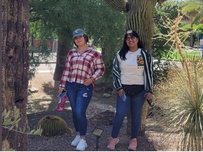 Mexican students Alondra Galdean and Keren Esquire stand in front of a tree for a picture.