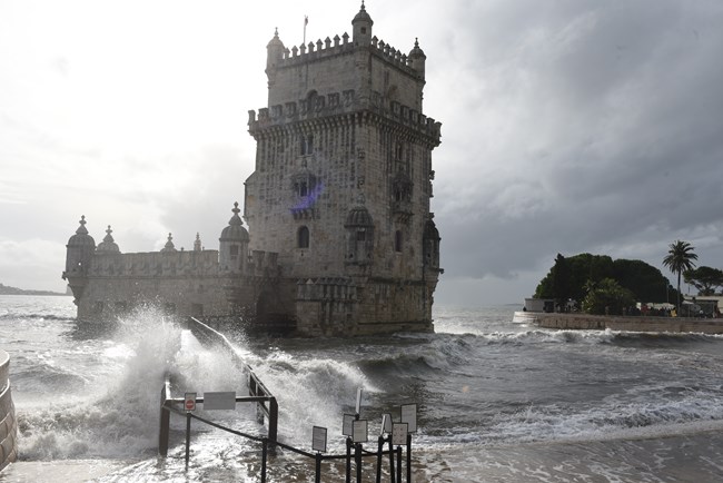A storm surge shows the effects of climate change on the Belem Tower, completely surrounding it by water.