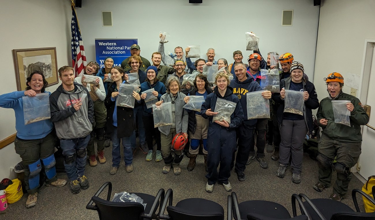 2024 lint camp group of people holding bags of lint collected from Lehman Caves