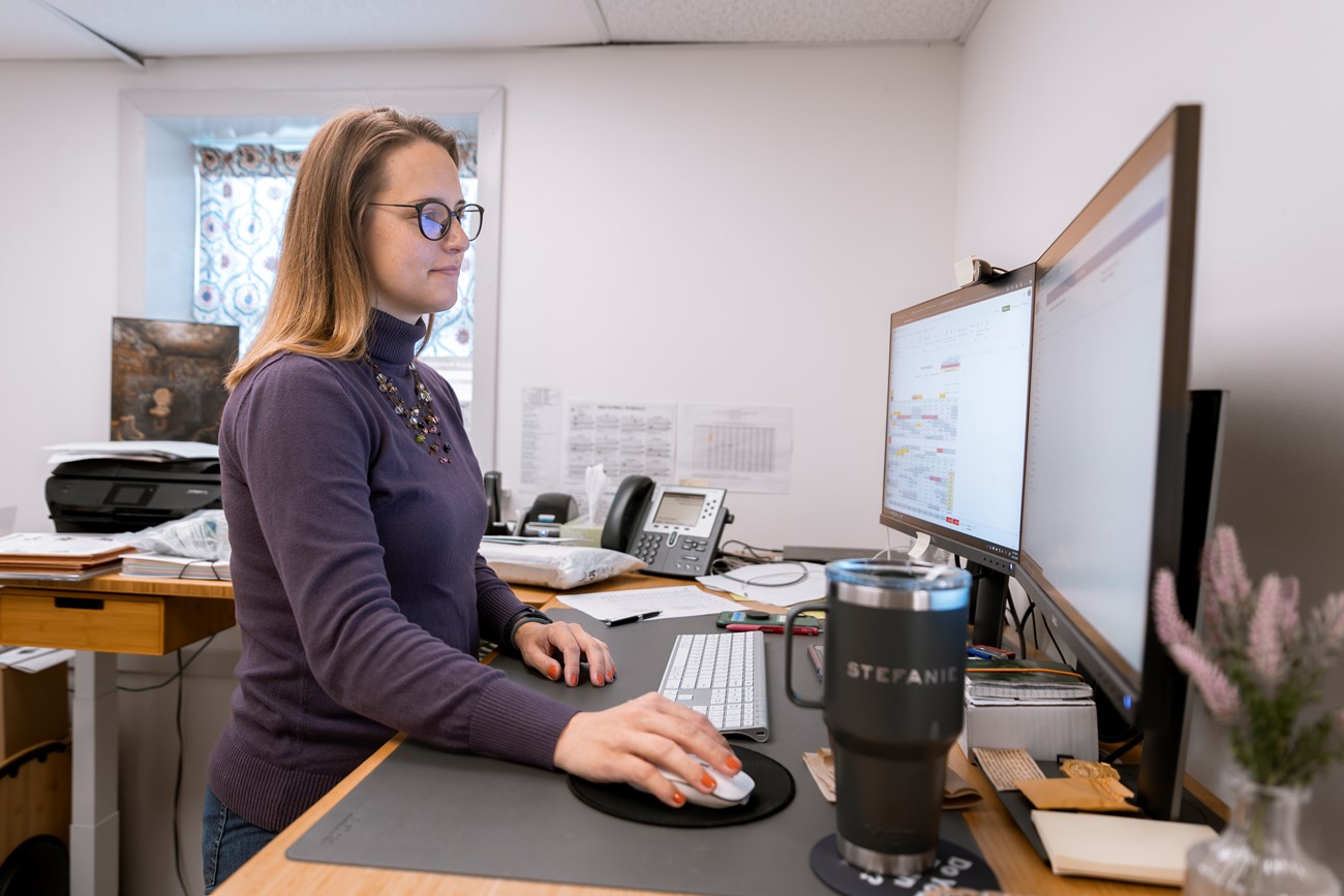 Woman works at an office desk.