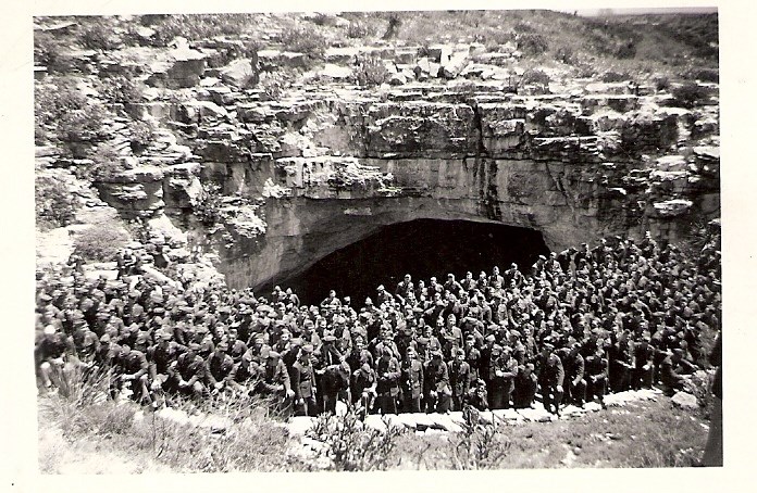 206th Coast Artillery visiting Carlsbad Caverns in 1941 Very large group of men in uniform standing in front of large cave opening.