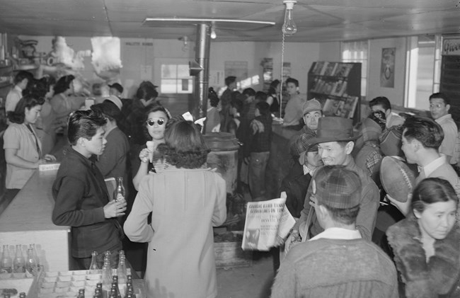 Interior of the cooperative canteen on a Sunday afternoon. A crowd inside a large room used as a store