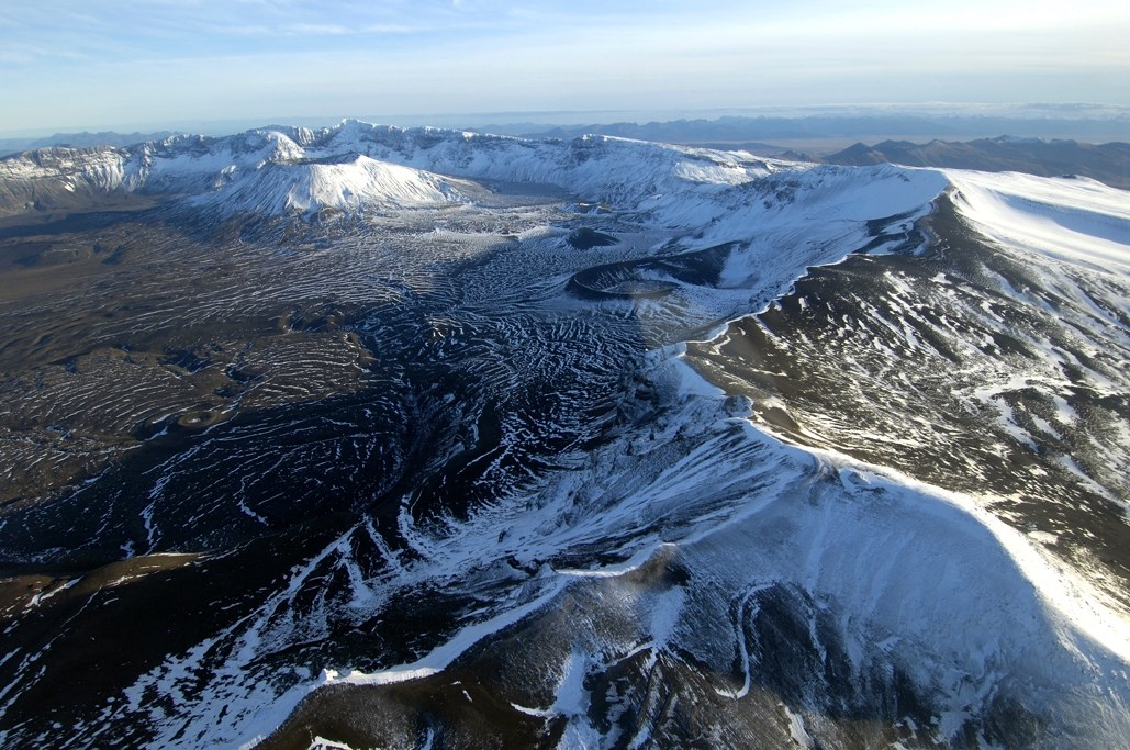 photo of the rim of a summit caldera with a dusting of snow