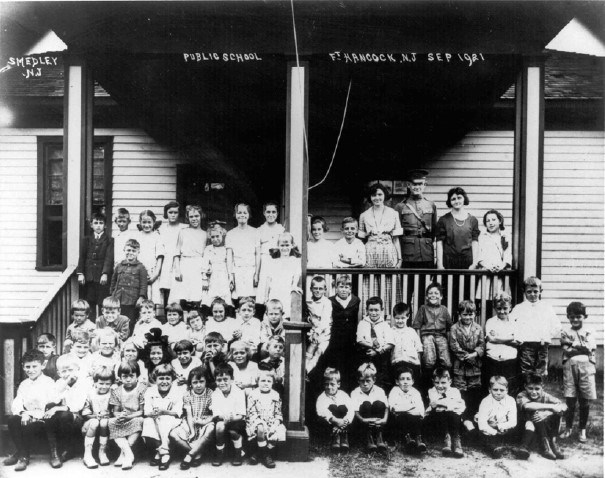 school children sit on the porch of an old school house