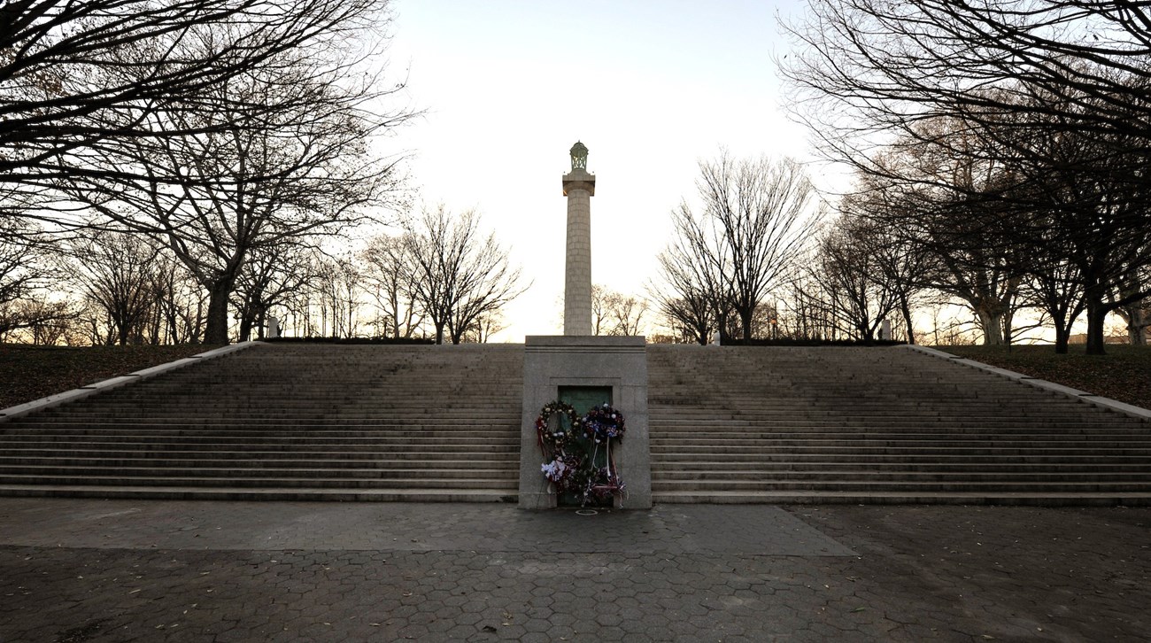 A stone crypt, wide stair case, and monument tower