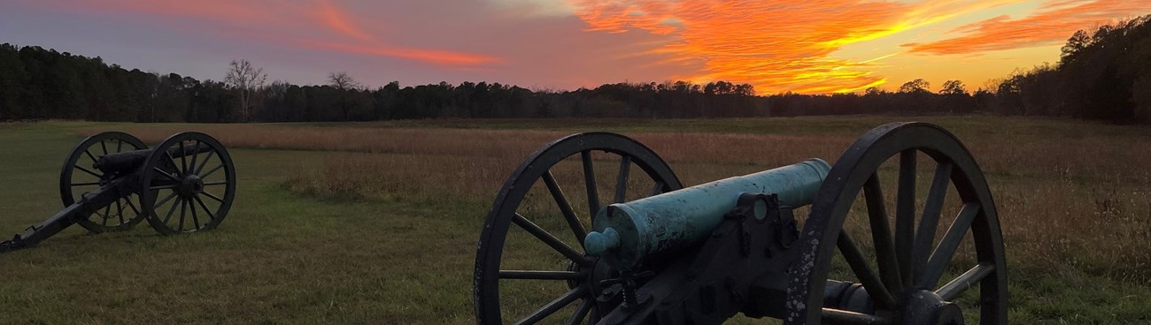 Cannons pointing out towards a pink sunset Cannons pointing out towards a pink sunset