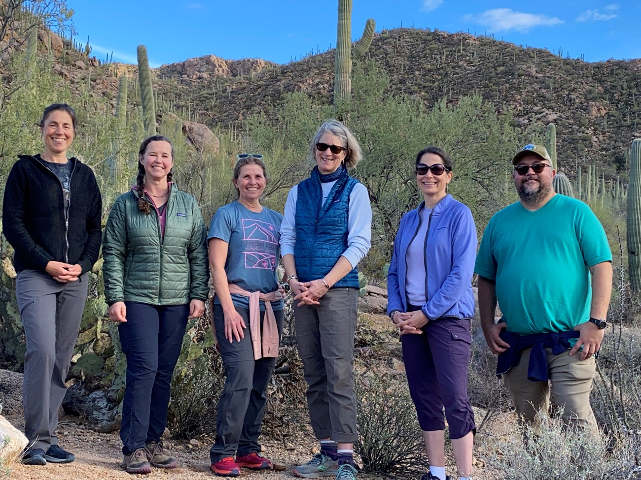 Group of six people with desert cactus in background