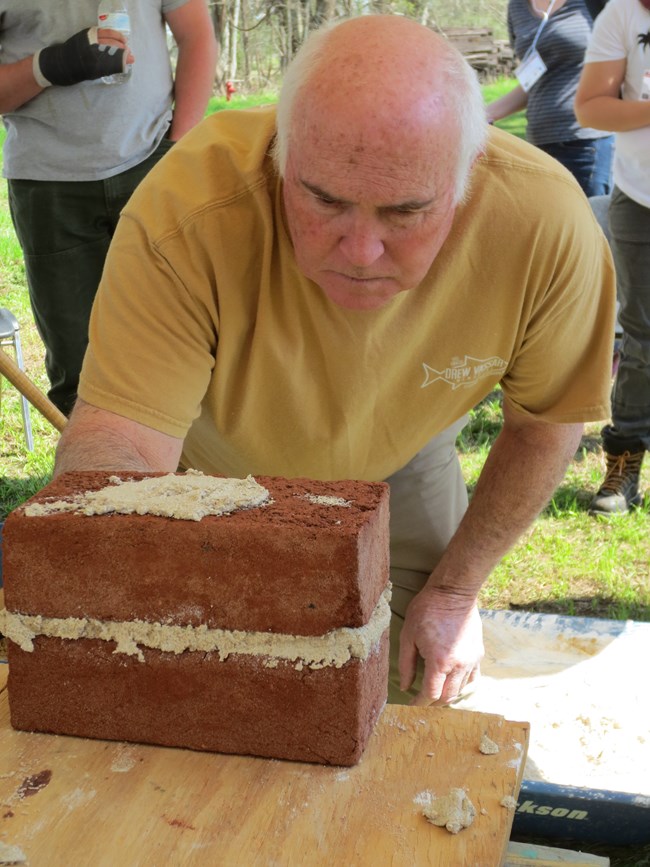 Red mason Jimmy Price demonstrating joint tooling techniques at a NCPTT workshop.