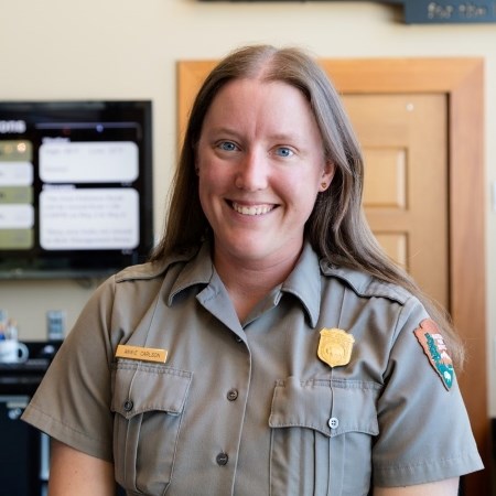 a park ranger in uniform and smiling at the camera