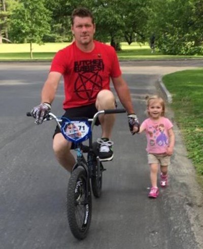 Chad on a bike with his daughter