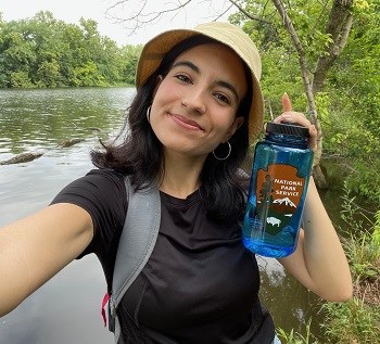 Nicole Segnini holding up a National Park Service water bottle on a hike