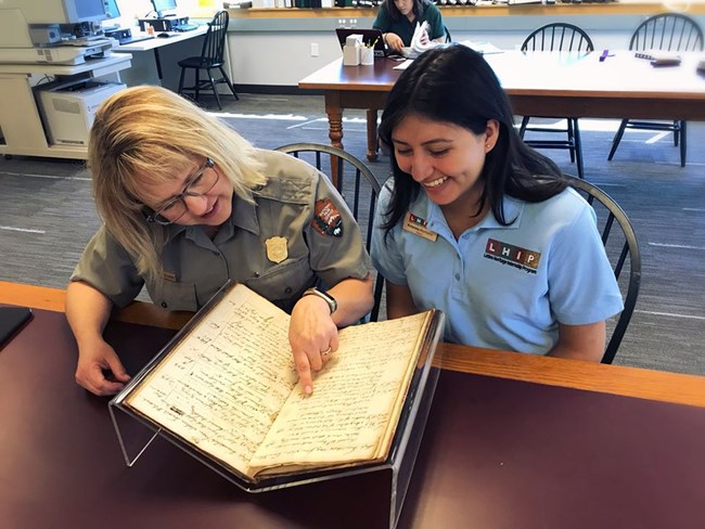 park ranger looks over a book with another woman