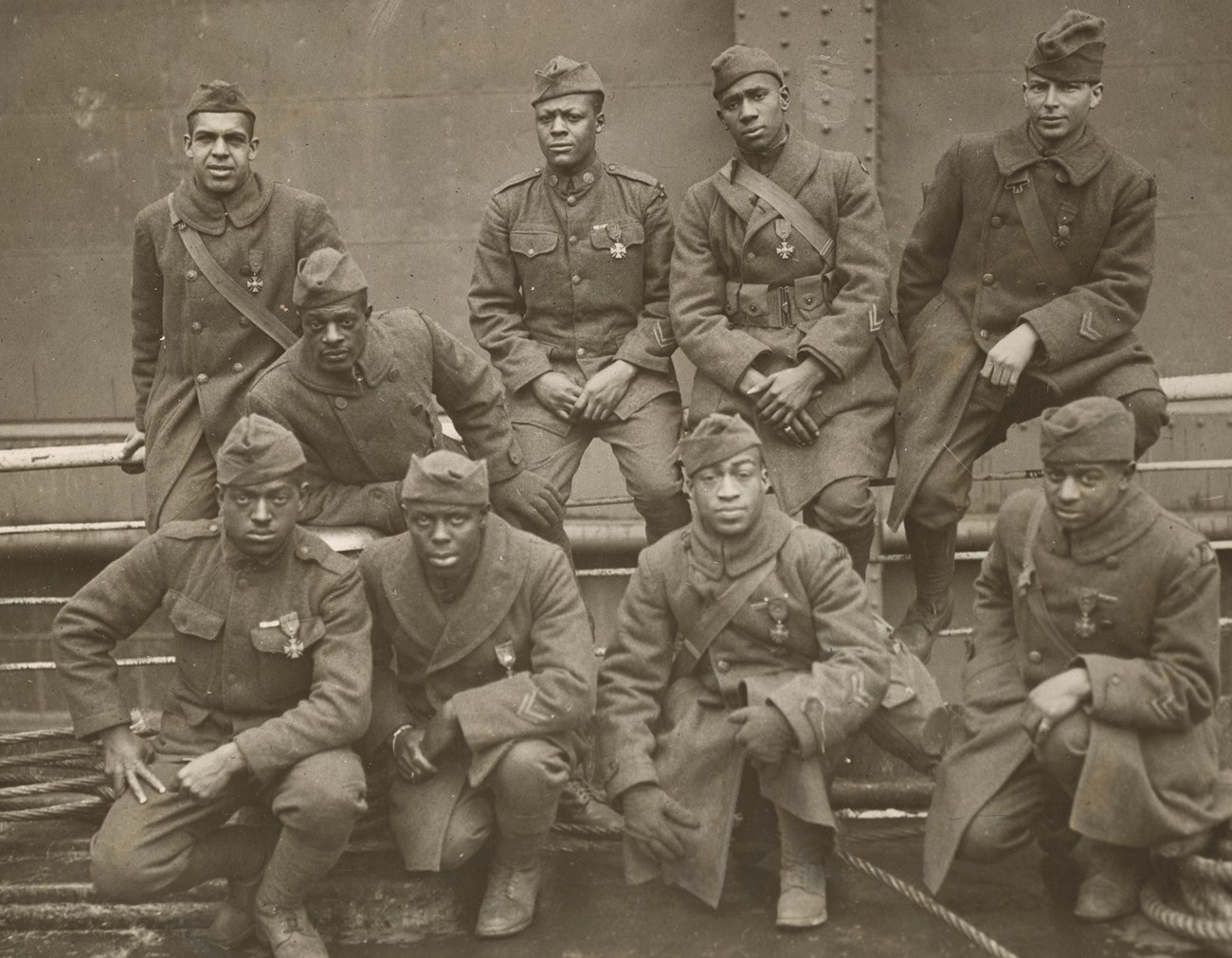 Group of nine African American World War One soldiers in two lines looking directly at the camera