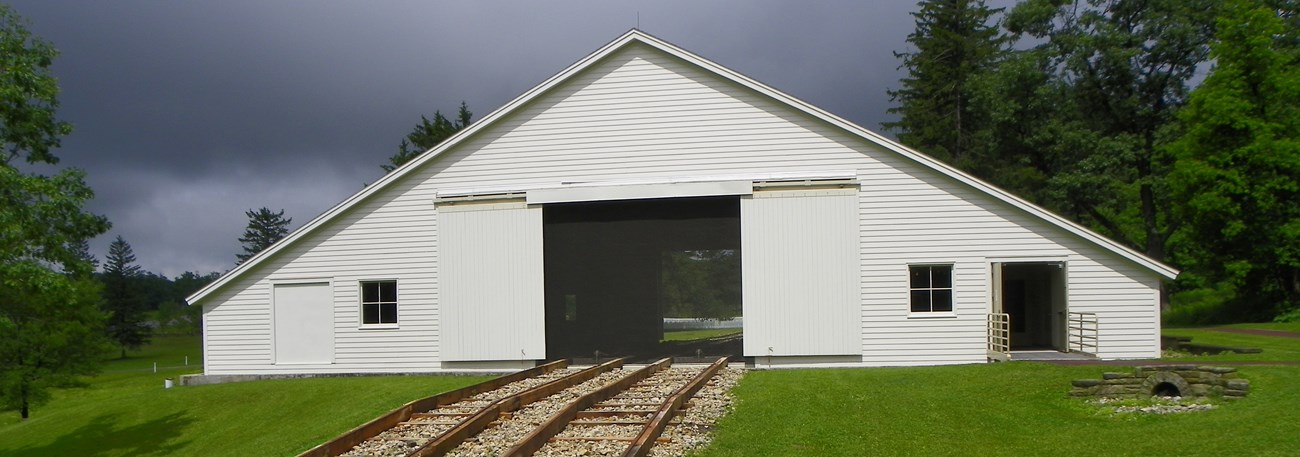 3728482778_e0f067abd4_o A white building with railroad tracks against a dark sky.