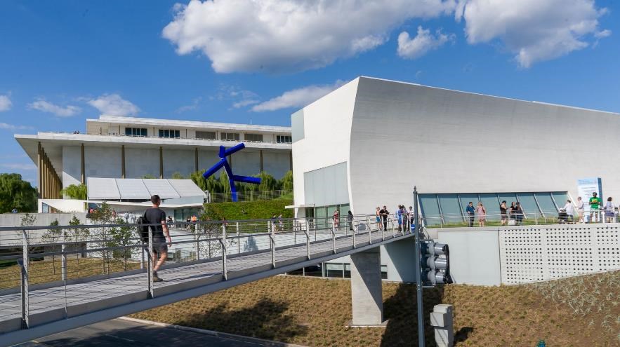 A man uses a footbridge to the Kennedy Center.