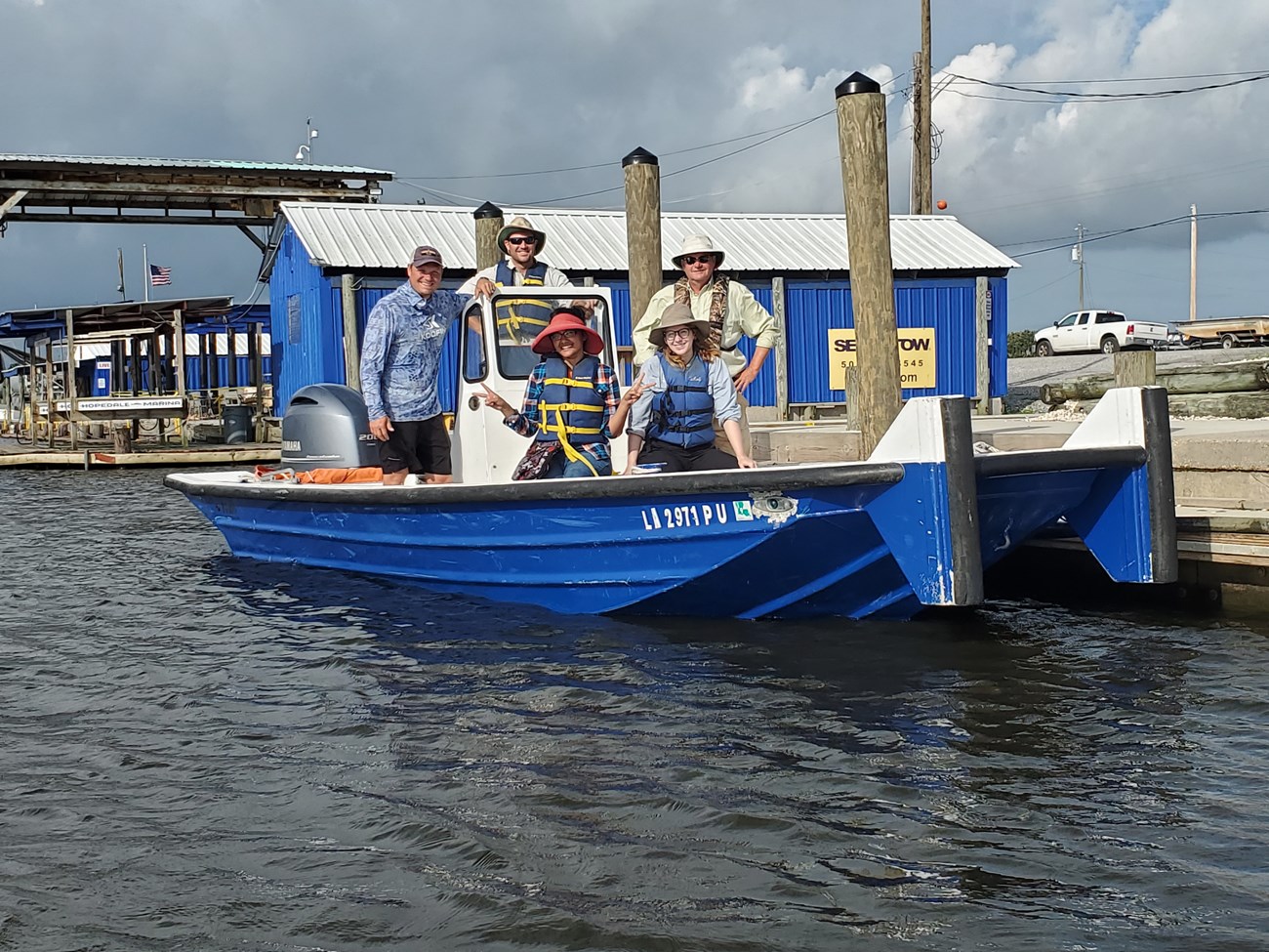 MRDAM Working Group members preparing to conduct fieldwork, posing for a picture on a boat. MRDAM Working Group members posing for a picture on a docked boat, preparing to conduct fieldwork.