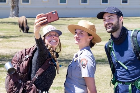 a park ranger posing with two other people for a selfie