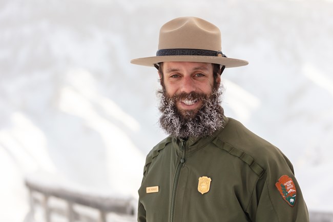 Watch Out for Winter Conditions a park ranger with snow in his beard