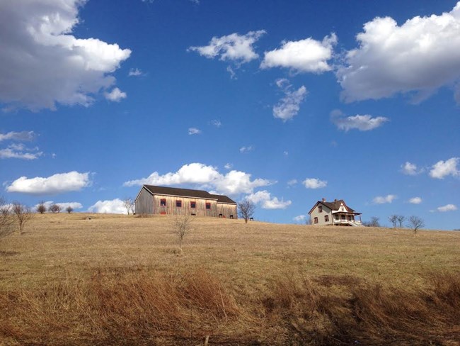 A farmhouse and barn under a blue sky A farmhouse and barn under a blue sky