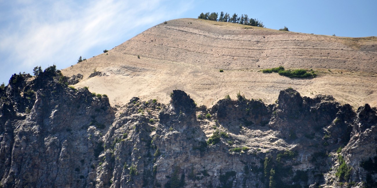 photo of rock cliff topped with layered ash deposits
