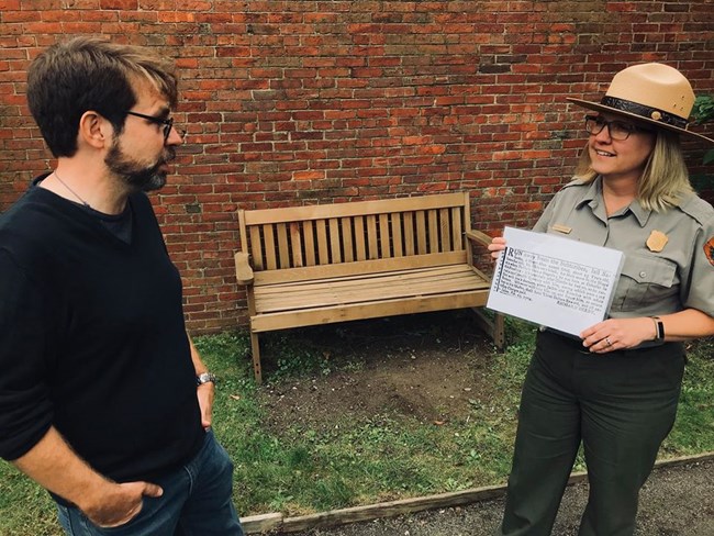 M Zujewski shares a 1774 runaway slave add placed by Richard Derby, with a park visitor. A park rangers shares a document with a visitor