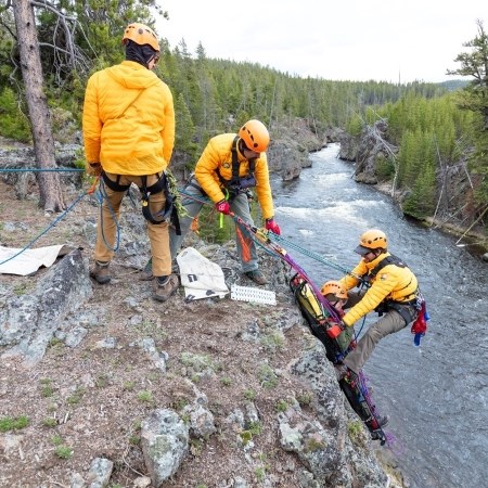 first responders rescuing a person from a cliffside