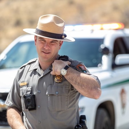 a park ranger talking on a radio