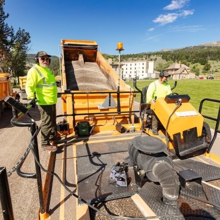 two people on a large machine used to repair roads