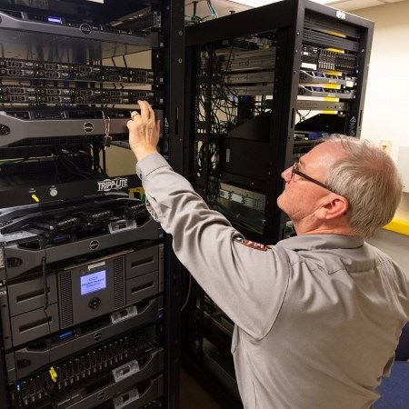 a park ranger standing in front of a lot of computer equipment