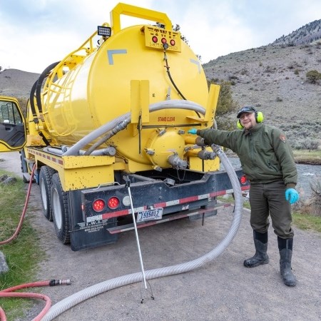 Pumping Vault Toilets a park ranger standing next to a large vehicle