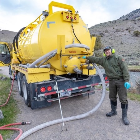 a park ranger standing next to a large vehicle