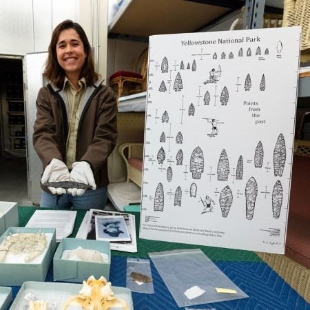 a person holding a museum collection item at a table