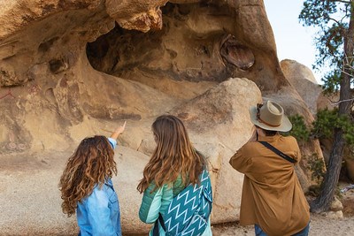 Three visitors look at Rock Writings at Barker Dam