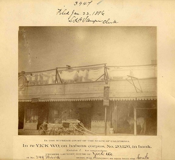 Yick Wo Laundry Sepia toned photo of a building exterior with a horse and cart. Label beneath says "In re Yick Wohabeas corpus"