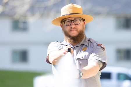 Be Bear Aware a park ranger spraying bear spray