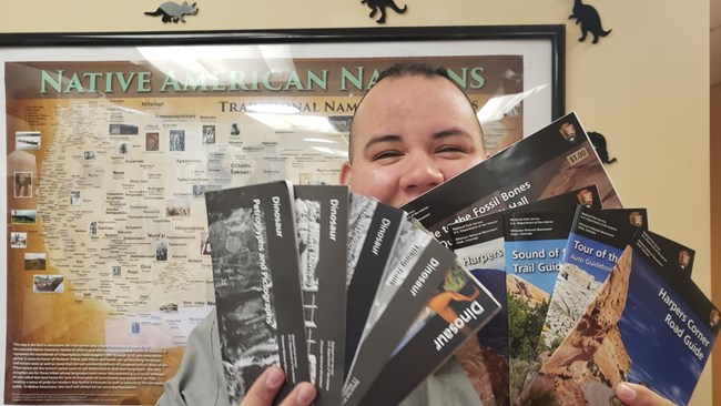 A ranger holds a variety of pamphlets of activities to explore.
