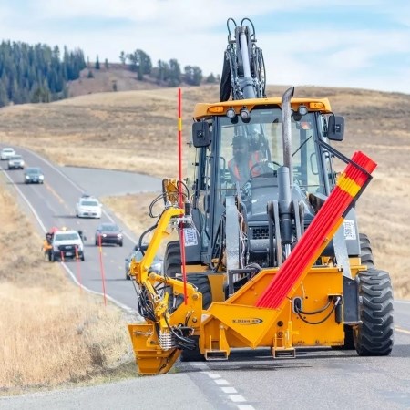 a person operating a large machine on a road