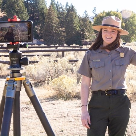 a park ranger in front of a phone set up on a tripod