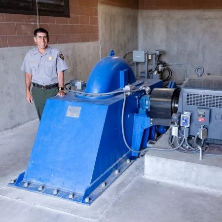 a park ranger standing next to a large generator