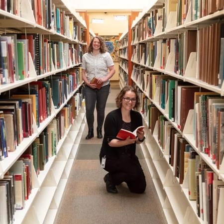 two people standing in a library aisle