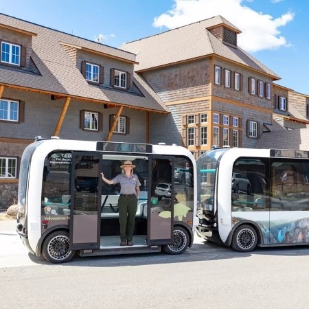 a park ranger standing in the doorway of an electric vehicle