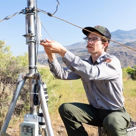 a park ranger collecting data from a climate site