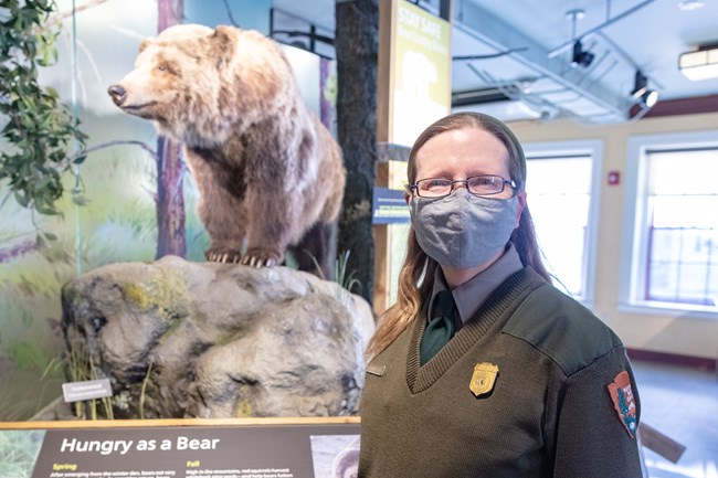 Protect Yourself and Others a park ranger wearing a mask inside a visitor center