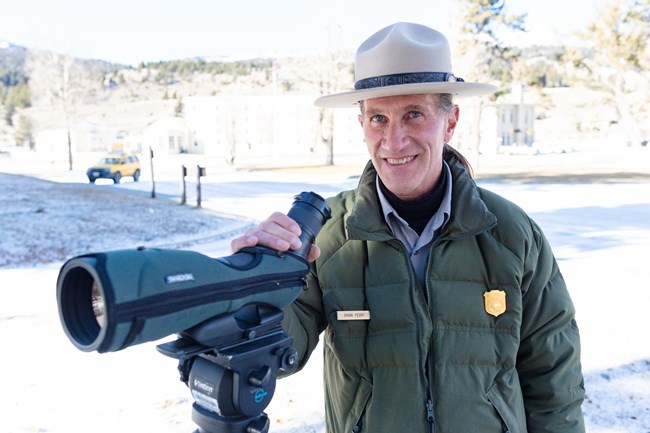 Give Wildlife Room, Use a Zoom a park ranger with a spotting scope